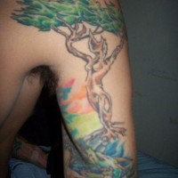 Tatuaje en el brazo, tronco de árbol con figura de mujer