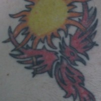 el tatuaje tribal de la ave magica fenix de color rojo con el sol