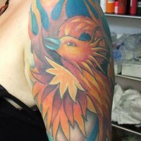 el tatuaje de la ave fenix de color naranja hecho en el hombro