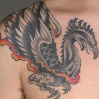 Black phoenix tattoo on chest