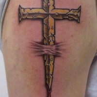 Goldenes Kreuz sticht Haut durch Tattoo