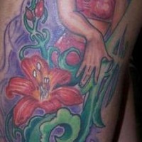 el tatuaje pin up con una chica y flores hecho en la cadera
