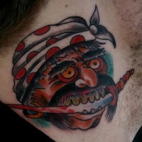 el tatuaje de la cabeza de un pirata asiato con el cuchillo en su boca