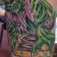el tatuaje de un esqueleto pirata de color verde con un baul de tesoro