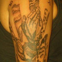 Praying hands arm tattoo