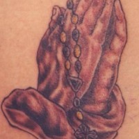 el tatuaje de las manos orantes con rosario
