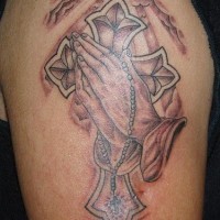 Praying hands and cross tattoo on shoulder