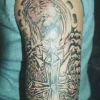 el tatuaje de jesucristo con la cruz hecho en el brazo