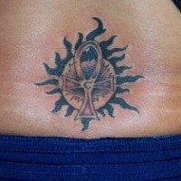 Sun and ankh tattoo on lower back
