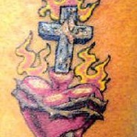 el tatuaje de una cruz con el corazon sagrado en las llamas de fuego