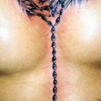el tatuaje de las manos orantes con un rosario y la cruz hecho en el pecho