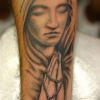 Angel sculpture with rosary tattoo