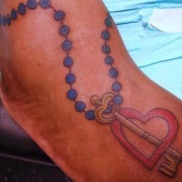 Tatuaje en color rosario con la llave dentro del corazón