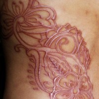 Impresioante tatauje sacrificio en la piel con muchos elementos florales