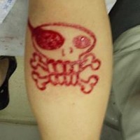Tatuaje sacrificio en la piella calavera loca con huesos