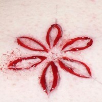 Flor minimalista tatuaje sacrificio en la piel
