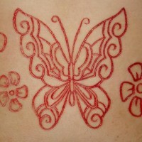 Tatuaje de mariposa con flores sacrificio en la piel