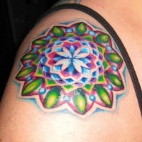 Tatuaggio colorato  sul deltoide il disegno in forma rotonda