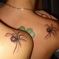 Le tatouage de l'épaule avec des araignées noires et un trèfle vert