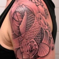 Tatuaggio grande colorato sul deltoide la carpa koi & i fiori
