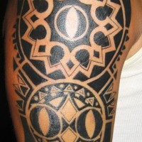 Tatuaggio grande colorato sul deltoide e sul braccio il disegno in stile tribale