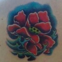 Tatuaggio colorato sulla spalla il papavero stilizzato