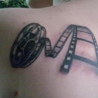 Tatuaje en hombro en negro y blanco cinta cinematográfica