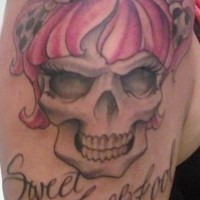Le tatouage de l'épaule avec la crâne de fille avec des nœuds et une inscription