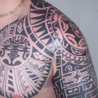 Shoulder tattoo, faces in pattern, black and white figures