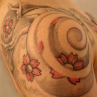 Tatuaggio non colorato sul deltoide i fiori nel vortice