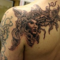 Le tatouage de l'épaule avec un visage sans émotion dans une plante poussant