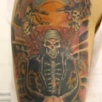 Le tatouage de l'épaule avec un squelette assis sur un chèvre au couche de soleil