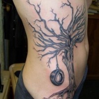 Tatuaggio sul fianco l'albero senza vita con la gomma sulla corda