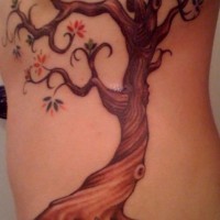 Le tatouage de flanc avec un beau arbre avec des petites fleurs
