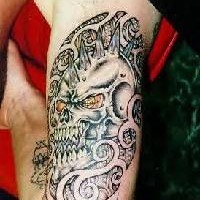 Tatuaje en tinta negra calavera del demonio en el brazo