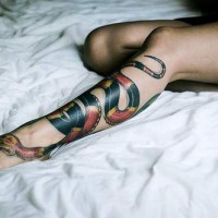 Red and black snake tattoo on leg