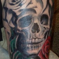 Leg tattoo, teethy skull with white and red roses