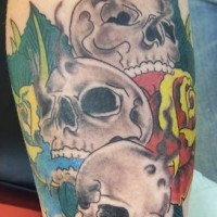 Three skulls and roses coloured tattoo