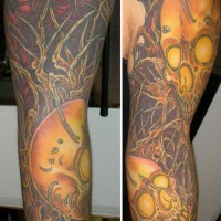 Shoulder tattoo of skulls and trees