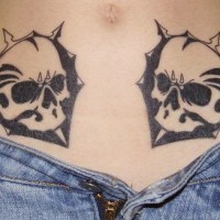 Stomach tattoo, two, black, symmetrical, angry skulls