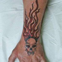 Calavera del diablo en las llams tatuaje ne el brazo