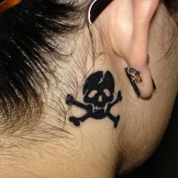 Schädel mit gekreuzten Knochen Tattoo hinter dem Ohr