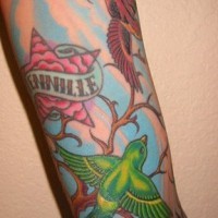 Pájaros multicolores en el árbol tatuaje en la manga