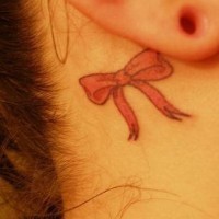 Red bow tattoo behind ear