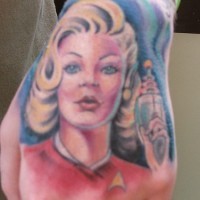 Une blonde avec un pistolet le tatouage sur la main