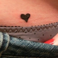 Very small, black, styled heart  hip tattoo