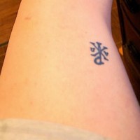 Símbolo en tinta negra tatuaje en la pierna