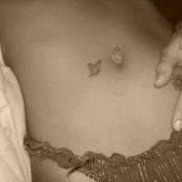 Small butterfly tattoo near tummy button