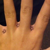 Kleine Sterne Tattoos zwischen den Fingern