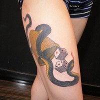 Dés avec un serpent le tatouage sur la jambe